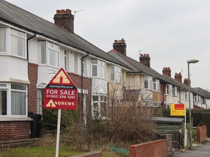 Row of houses with For Sale signs